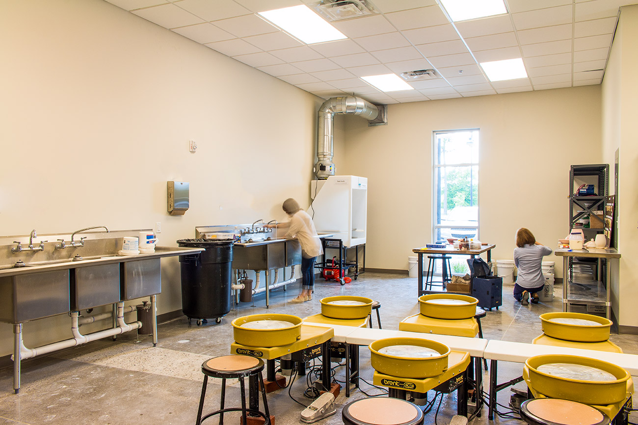 Two people enjoy the pottery room in the Leland Cultural Arts Center